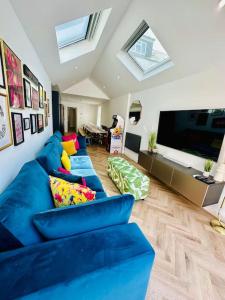 a living room with blue couches and a flat screen tv at Social Central - No 1 for large groups in Cardiff