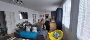 a living room with a blue couch and a yellow chair at Issoudun appart élégant 150m² in Issoudun