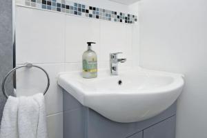 a white bathroom sink with a soap bottle on it at Croft House - By Sigma Stays in Crewe