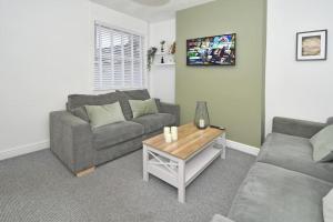 a living room with a couch and a coffee table at Croft House - By Sigma Stays in Crewe