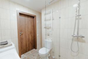 a bathroom with a toilet and a glass shower at New Modern studio apartment next to the city centre in Vilnius