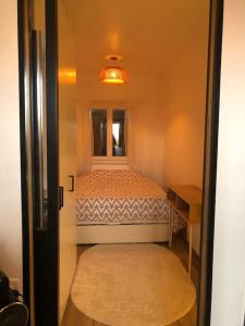 a small bedroom with a bed and a window at Cocooning little house in Viry-Châtillon