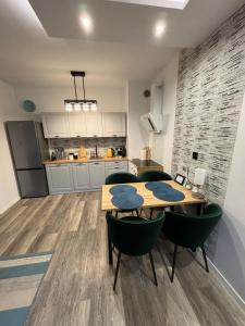 a kitchen and dining room with a table and chairs at Apartament Kamila Ostróda in Ostróda