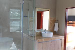 ウィルダネスにあるTURACO HOUSEの洗面台とガラスのシャワーを備えたバスルーム +23枚の写真