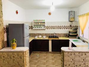 Il comprend une cuisine équipée d'un réfrigérateur et d'un comptoir. dans l'établissement Résidence Aquilaria Dar Nouha, à El Haouaria