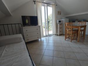 a living room with a television and a table and chairs at Apartment Kumbor in Herceg-Novi