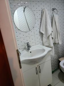 a white bathroom with a sink and a mirror at Villa Elear in Korçë