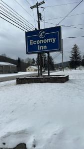 una señal para una posada económica en la nieve en Economy Inn en Alfred