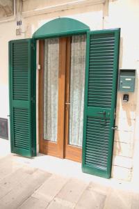 Una puerta con persianas verdes en un edificio. en Conte Ugolino 71, en Martina Franca