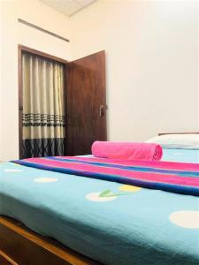 two beds in a room with colorful blankets on them at Talpe Inn in Unawatuna +2 photos