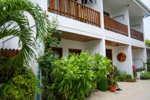 a white building with plants and a balcony at Akiri Dhigurah in Dhigurah