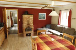 a living room with a couch and a table and a fireplace at Ferienhaus am Wald mit Klavier, Holzofen, Sauna in Alt Jabel