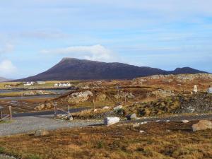 a view of a hill with a mountain in the background at Grimsay Glamping, North Uist - Pod Ruadh in Rossinish