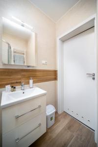 ein Badezimmer mit Waschbecken und Spiegel in der Unterkunft La Vida apartman Hajdúszoboszló in Hajdúszoboszló + 21 Fotos