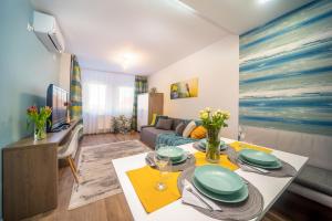 ein Wohnzimmer mit einer Couch und einem Tisch in einem Zimmer in der Unterkunft La Vida apartman Hajdúszoboszló in Hajdúszoboszló