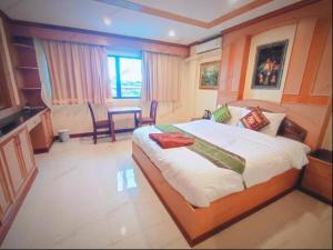 a bedroom with a large bed and a table at Pauna Inn Pattaya in Pattaya South