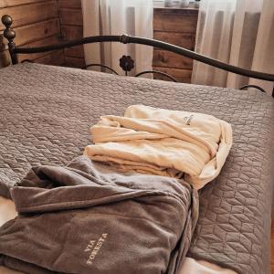 ein Bett mit zwei Handtüchern drauf in der Unterkunft Viaforesta 