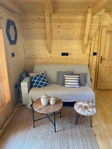 una habitación con sofá y mesa en una cabaña en Nice cabin en Cetinje