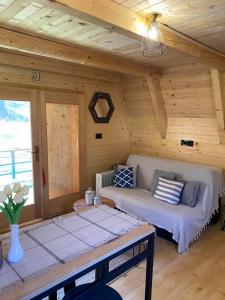 une chambre avec un canapé dans une cabane en rondins dans l'établissement Nice cabin, à Cetinje