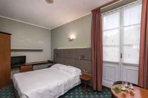 um quarto de hotel com uma cama e uma janela em Manuelina Taste Hotel em Recco