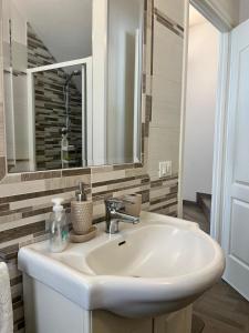 ein Badezimmer mit einem weißen Waschbecken und einem Spiegel in der Unterkunft Casa Giulia in Marina di Leuca