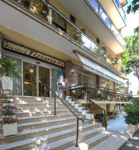 a building with stairs in front of a restaurant at Hotel Tiziana in Rimini