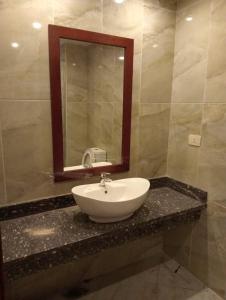 een badkamer met een wastafel en een spiegel op een aanrecht bij Oyster bay beach resort in Marsa Alam