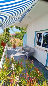 un patio con 2 sedie e una panchina su una casa di Vesna - room with private bathroom near sea a Trogir