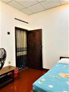 a room with a bed and a door and a table at Talpe Inn in Unawatuna
