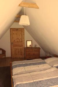 sypialnia z łóżkiem, komodą i drabiną w obiekcie Ferienhaus am Wald mit Klavier, Holzofen, Sauna w mieście Alt Jabel