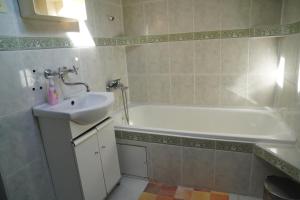 a bathroom with a sink and a bath tub at Penzion Veronika in Štrba