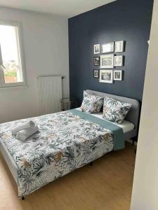 1 dormitorio con cama y pared azul en Appartement chaleureux à proximité de Paris, en Saint-Michel-sur-Orge