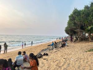 un grupo de personas de pie en una playa en Nexus 25, en Colombo