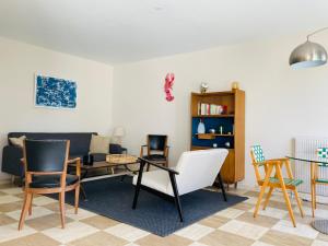 een woonkamer met een bank en een tafel en stoelen bij Piriac, maison familiale, accès direct plage, 12 couchages in Piriac-sur-Mer
