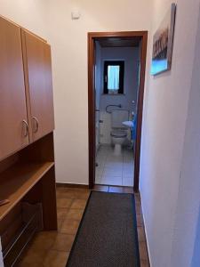 a hallway to a bathroom with a toilet in it at seeglueck SEENSUCHT seenah in Reichenau