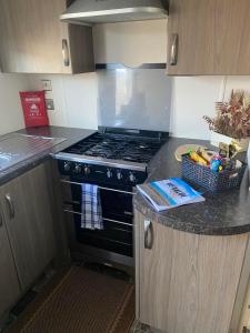 a kitchen with a stove and a counter top at Orchid meadows retreat in Ashington