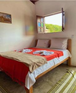 a bedroom with a large bed with a window at CHALES DA SERRA in Bananeiras