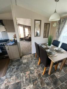 a kitchen and dining room with a table and chairs at Orchid meadows retreat in Ashington