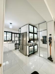 eine Küche mit einem Kühlschrank aus Edelstahl und Fenstern in der Unterkunft Maison lumineuse à Torcy in Torcy