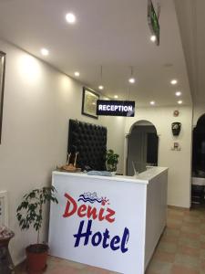 a dental hotel with a sign on a reception desk at Deniz Hotel in Finike