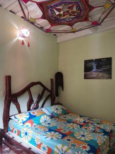 una camera con letto e soffitto in vetro colorato di POSADA KAUAI a Mocoa