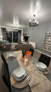 a dining room with a table with plates and wine glasses at Manchester City football Stadium View in Manchester