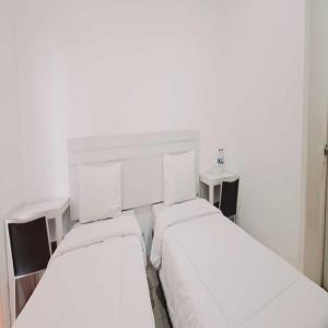 タンゲランにあるTos Residenceのベッド2台が隣同士に設置された部屋です。