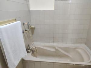 a white bath tub in a bathroom with a towel at Askari Gold Crest in Peshawar