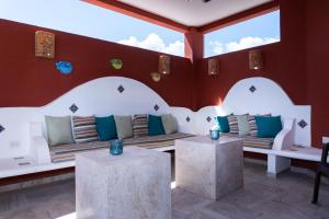 Habitación con 2 sofás blancos y 2 mesas. en Magic Paradise by BVR, en Playa del Carmen