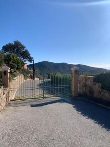a gate to a house with mountains in the background at Suite dans un petit paradis in La Londe-les-Maures