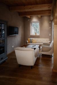 een woonkamer met een bank en stoelen en een tv bij Holzmichel 