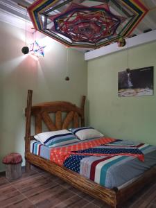 una camera con letto in legno e soffitto colorato di POSADA KAUAI a Mocoa