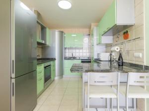 プラヤ・ハンディアにあるApartamento Balcon De Jandiaのキッチン(緑のキャビネット、冷蔵庫付)