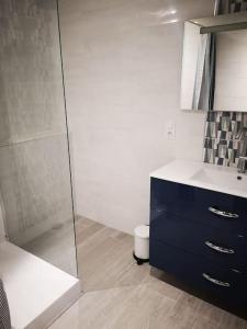 La salle de bains est pourvue d'une douche et d'une commode bleue. dans l'établissement Tout le charme de La Baule-Les -Pins T3 73m2, à La Baule